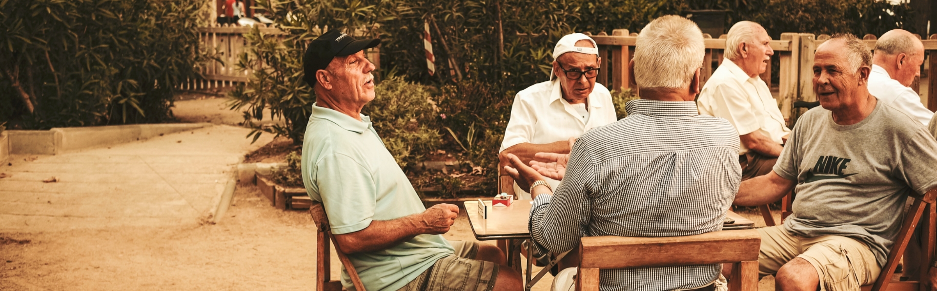 Imatge d'un grup de senyors jugant al domino en una taula